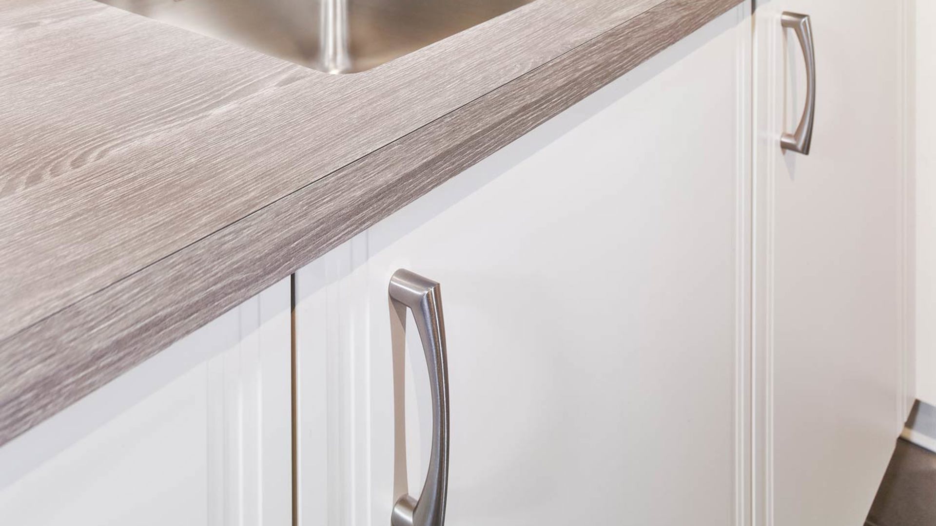 Tijdloze hoekkeuken met houtlook werkblad en verticale handgreep