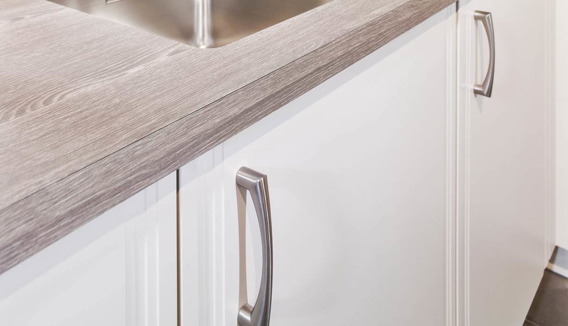 Tijdloze hoekkeuken met houtlook werkblad en verticale handgreep