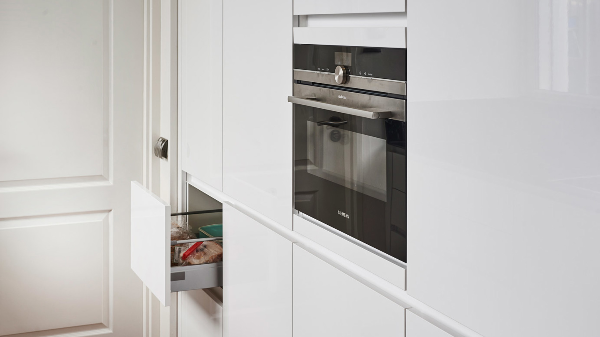 Parallelle keuken in Zeeland met greeploos front in hoogglans wit