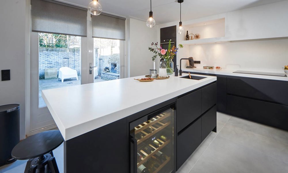 Mat zwarte keuken Beverwijk met wit Corian aanrechtblad