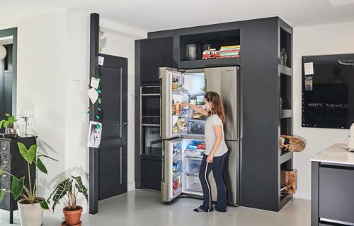 Zwart witte keuken met kastenwand met apparatuur