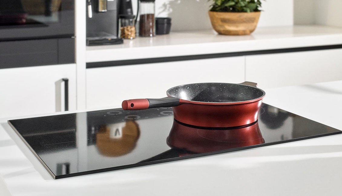 Witte keuken met zwarte inductiekookplaat
