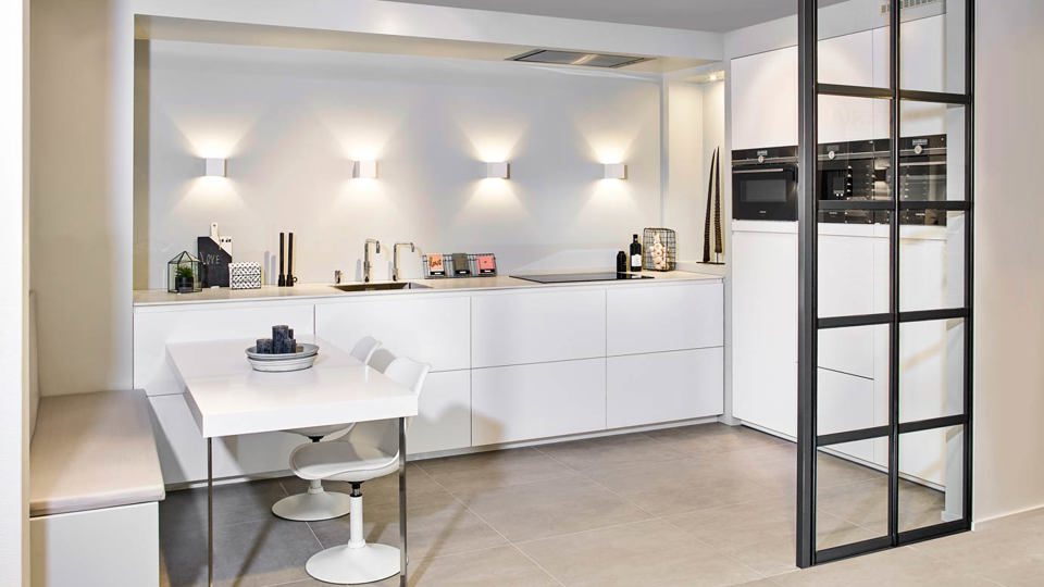 Witte open keuken met eethoek