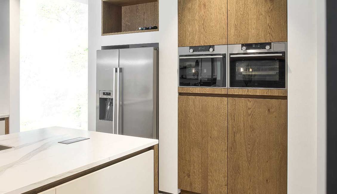 Houten kastenwand met ovens in eilandkeuken 