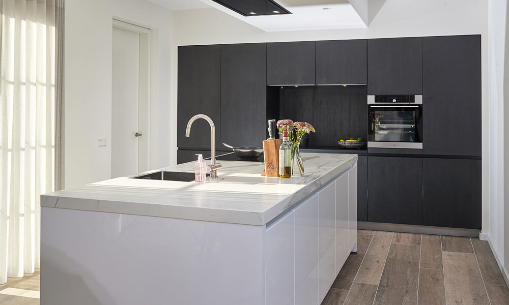 Witte eilandkeuken met zwarte kastenwand