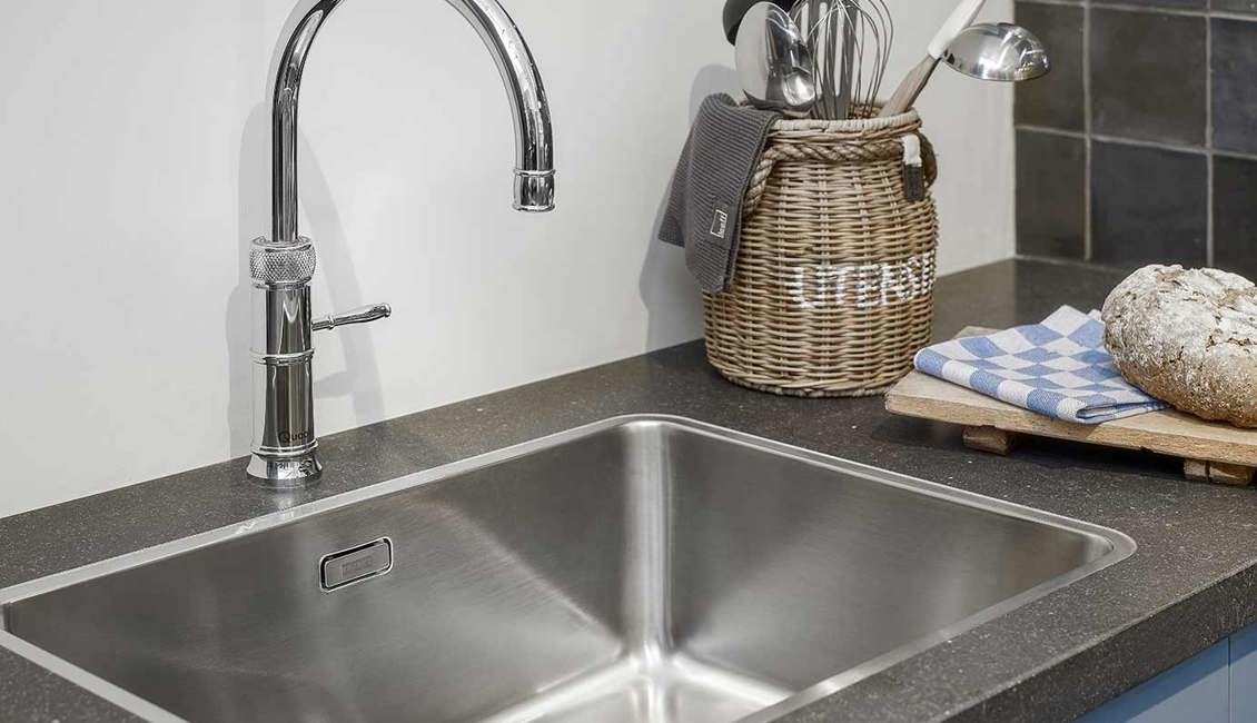 Blauwe keuken met kraan en spoelbak