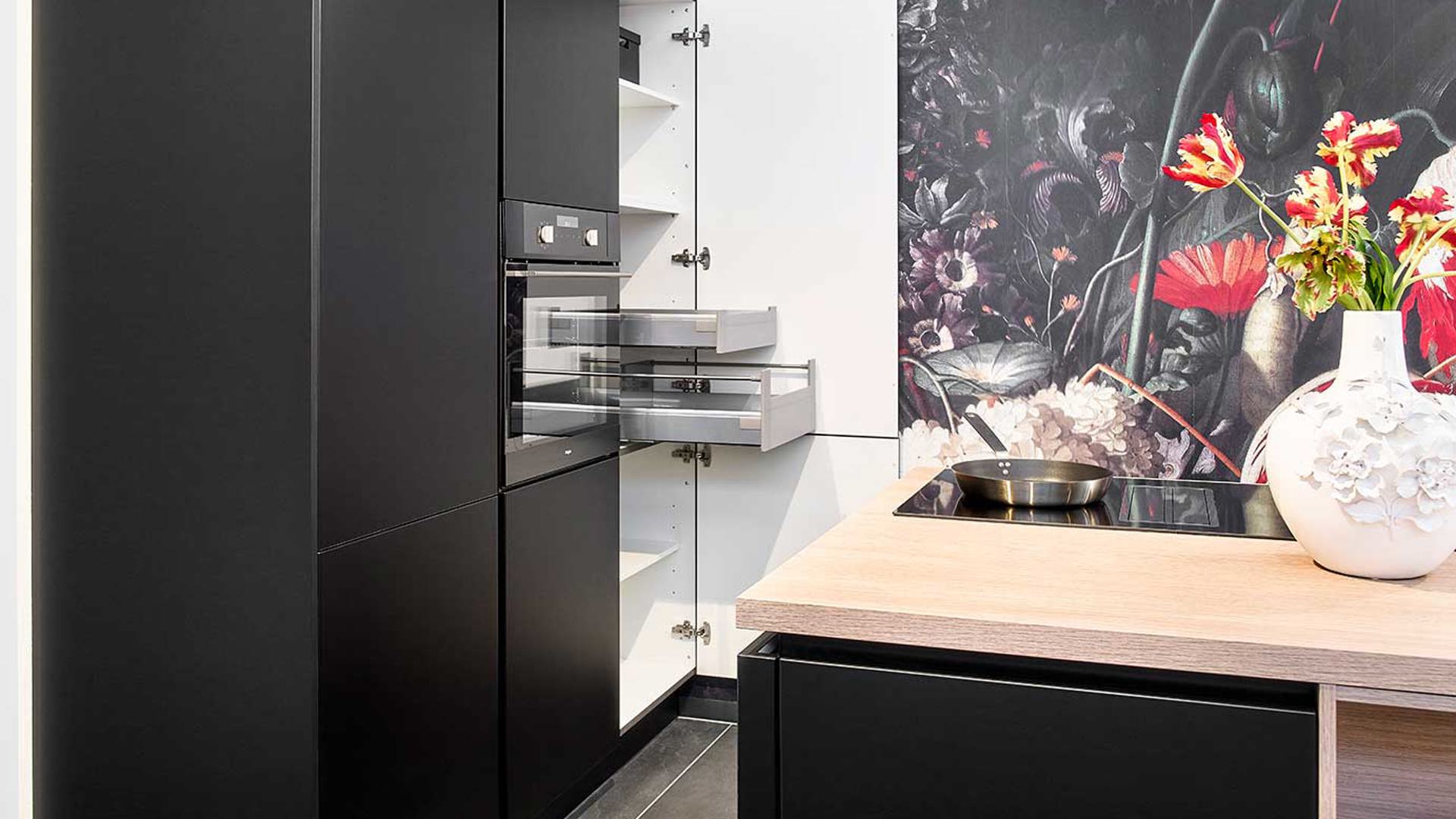 Zwarte eilandkeuken met kastenwand, binnenwand kast