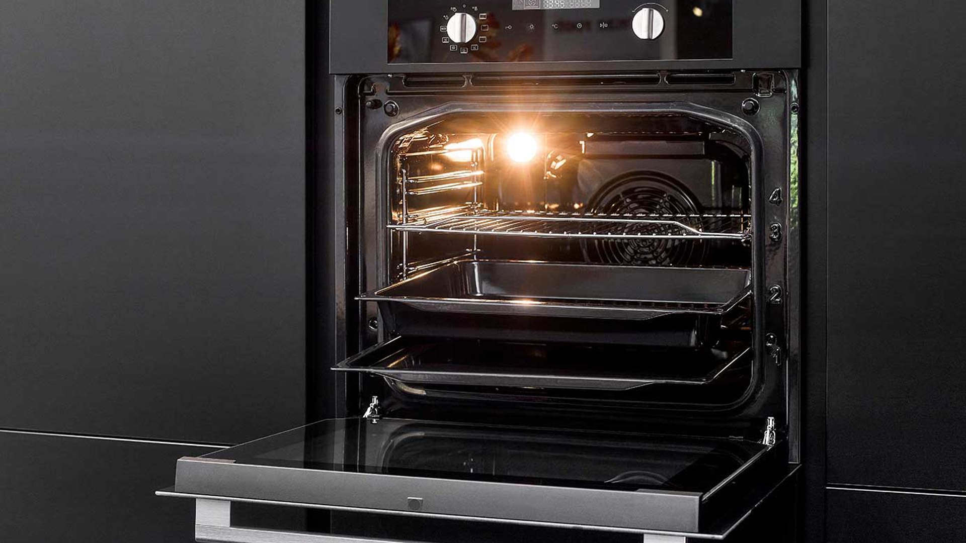 Zwarte eilandkeuken met kastenwand, oven