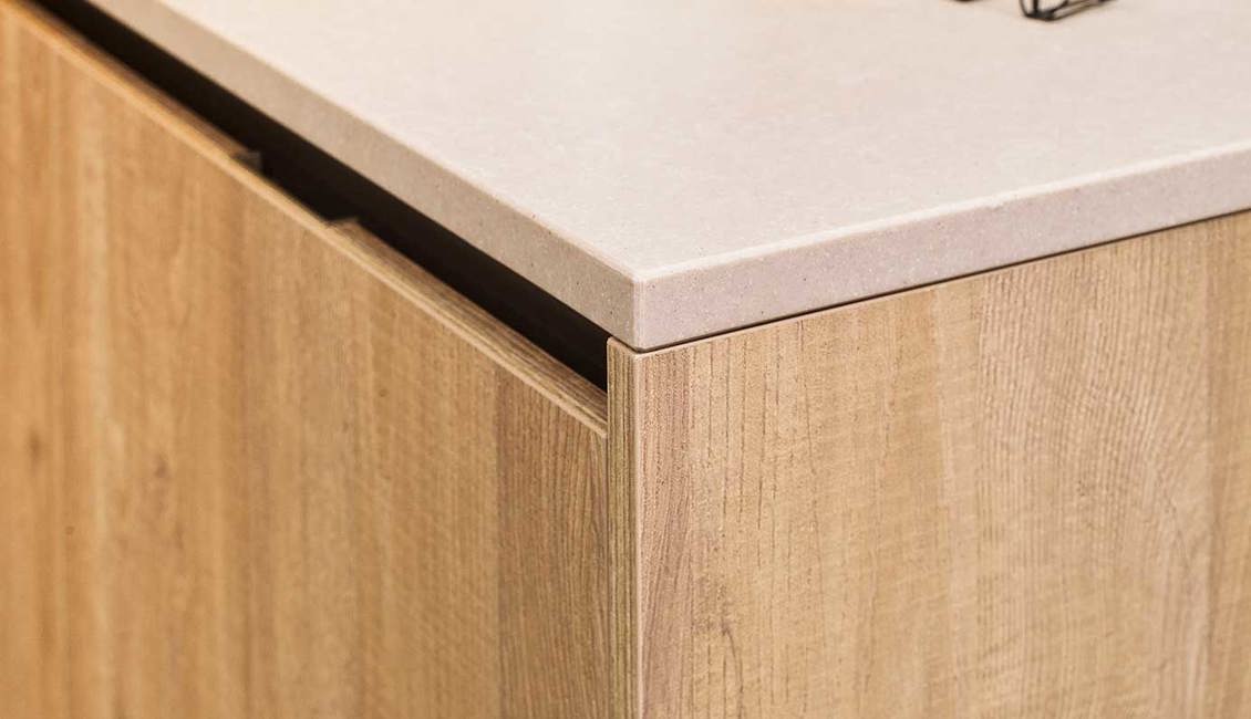 Greeploos houten hoekkeuken met composiet aanrechtblad