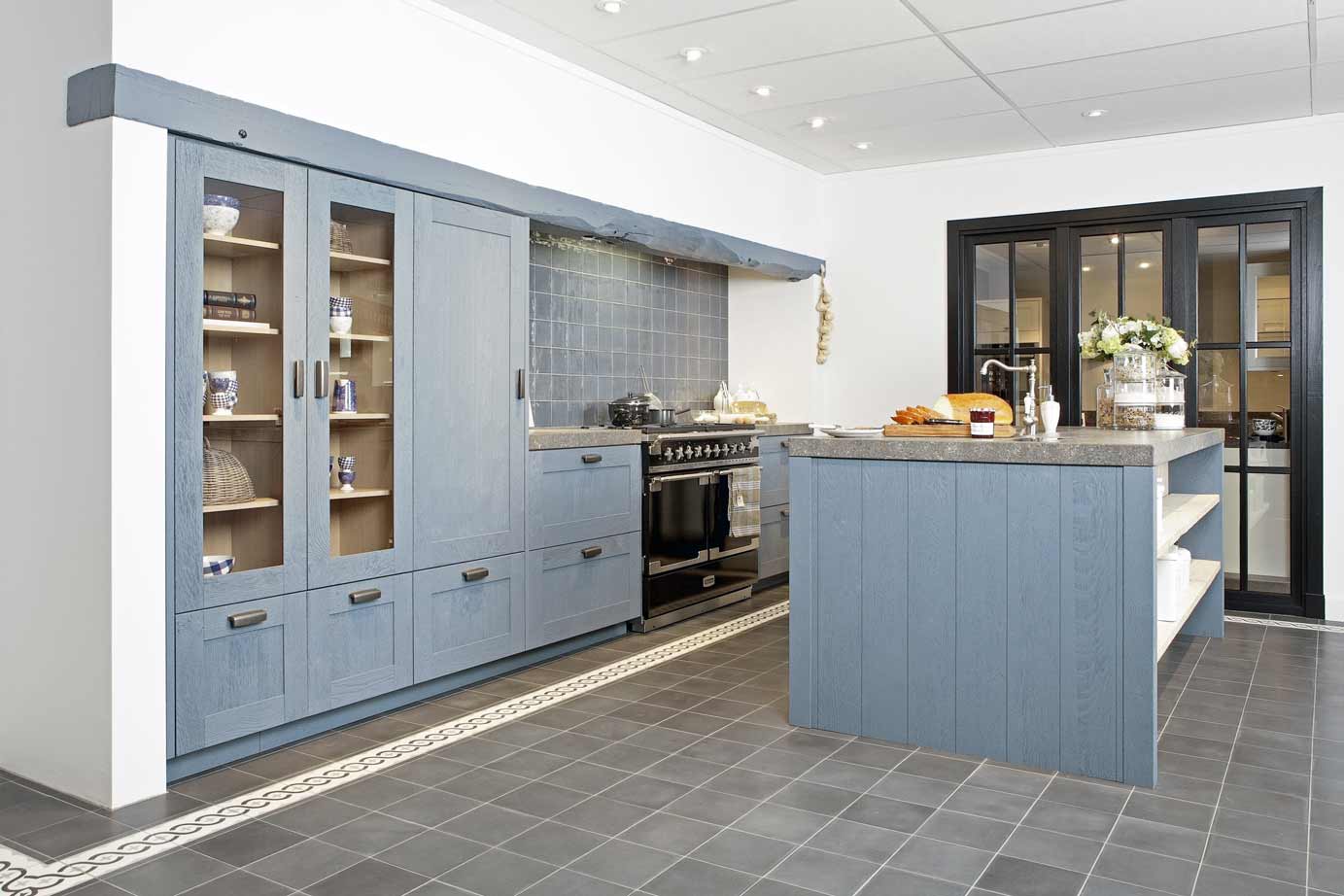 Blauwe klassieke keuken met eiland en fornuis