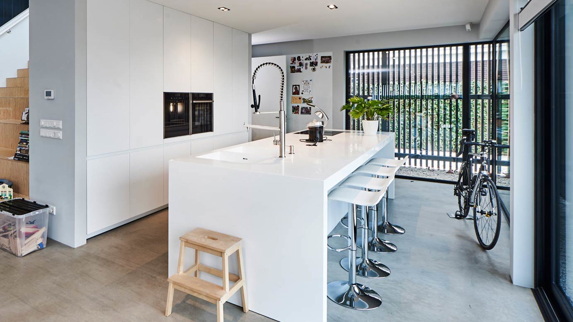 Moderne keuken met kookeiland en kastenwand in de kleur wit