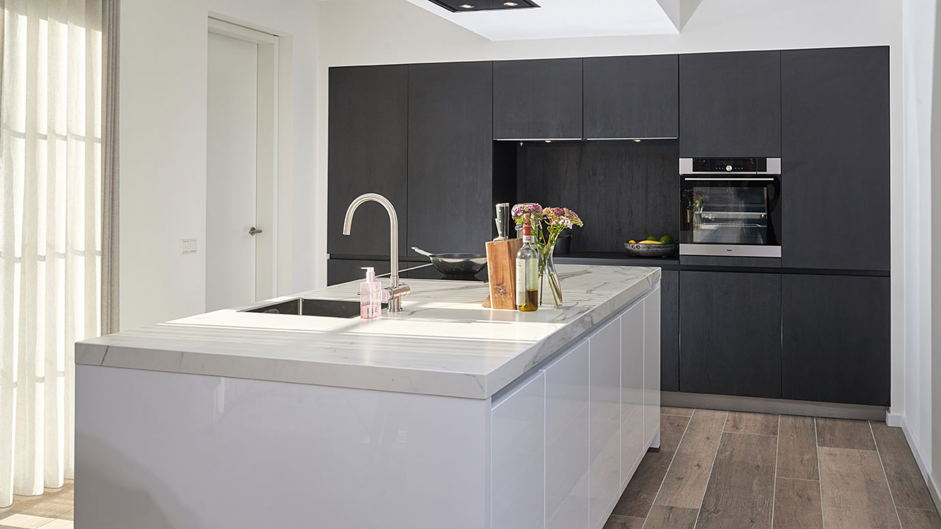 Hoogglans keuken met zwarte kastenwand van hout