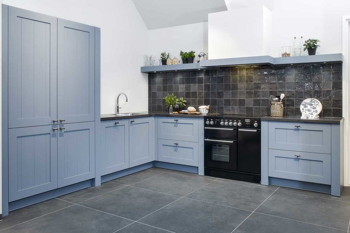 Blauwe rustieke keuken van hout, met fornuis en kastenwand