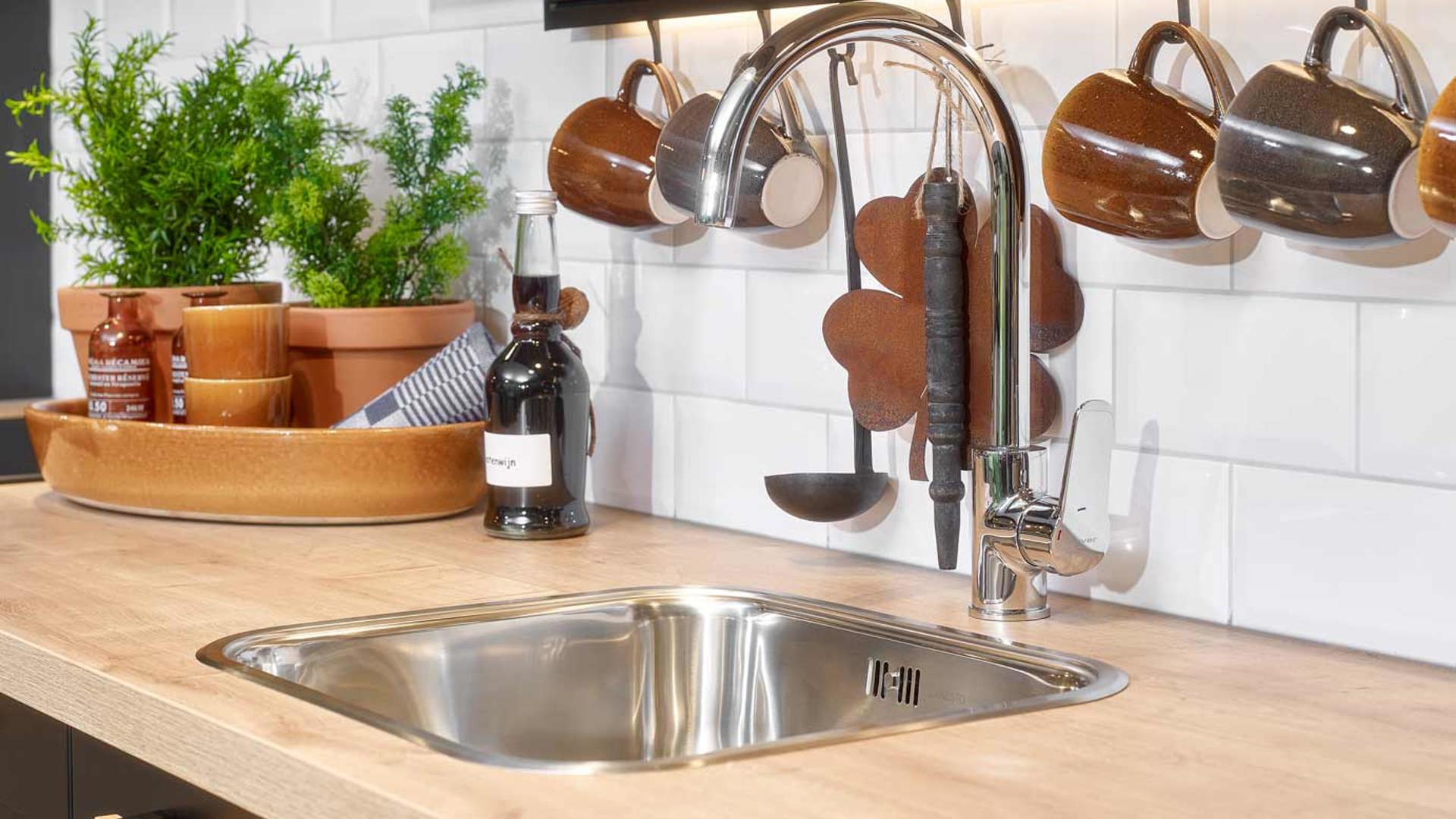 Landelijk zwarte keuken, kraan en spoelbak