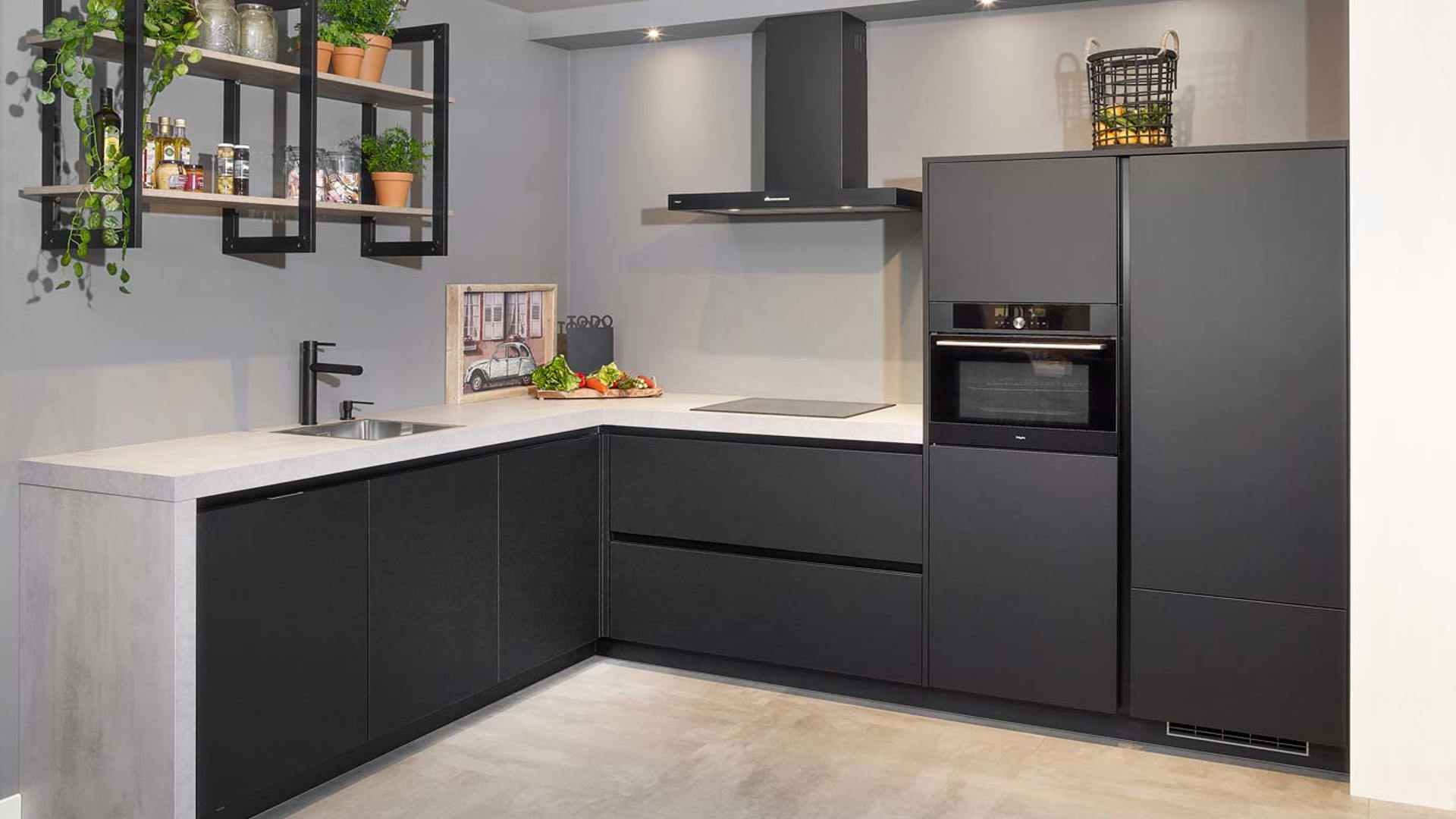 Mat zwarte keuken in moderne stijl, met betonlook aanrechtblad