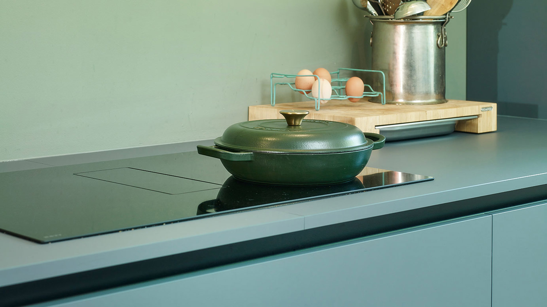 Moderne groene keuken, inductiekookplaat met afzuiging