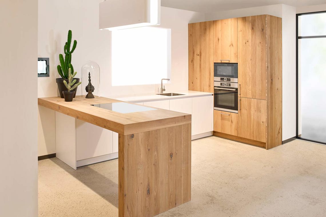 Design keuken met houten bar en kastenwand