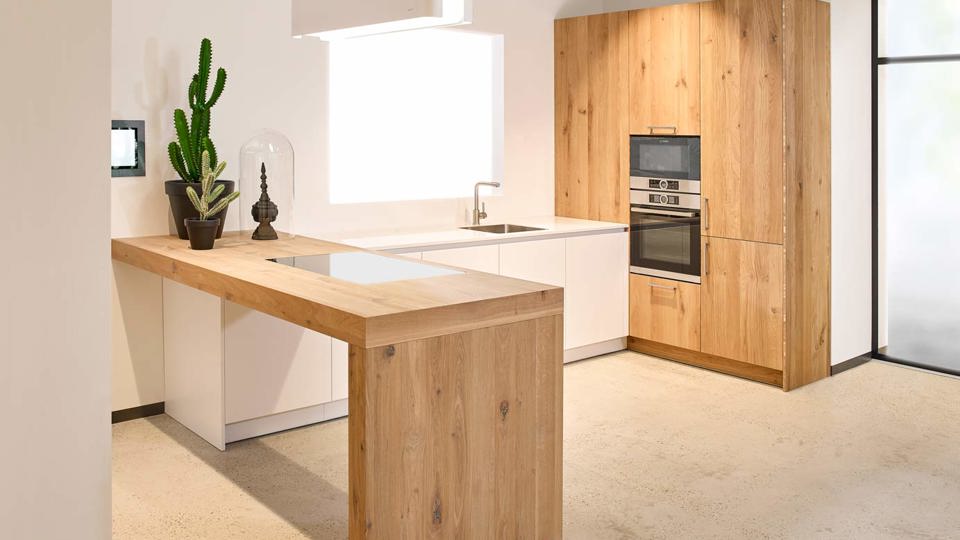 Design keuken met houten bar en kastenwand