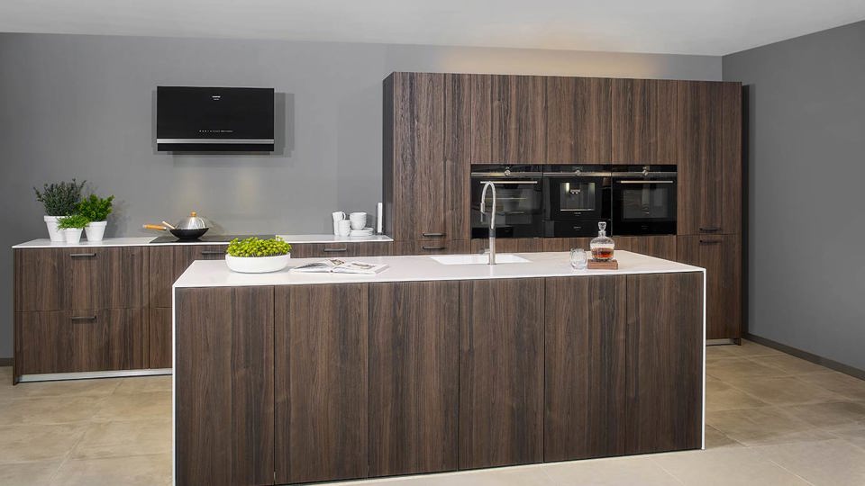 Houten design keuken greeploos met eiland en kastenwand
