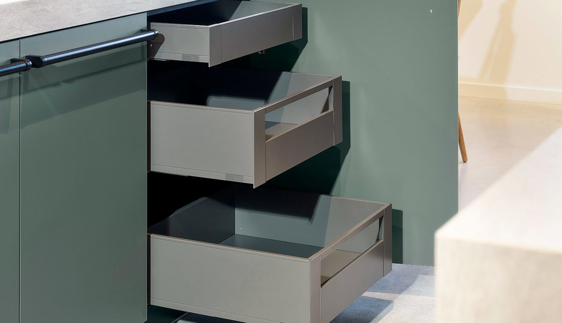 Groene keuken met eiland, lades achter kastdeur