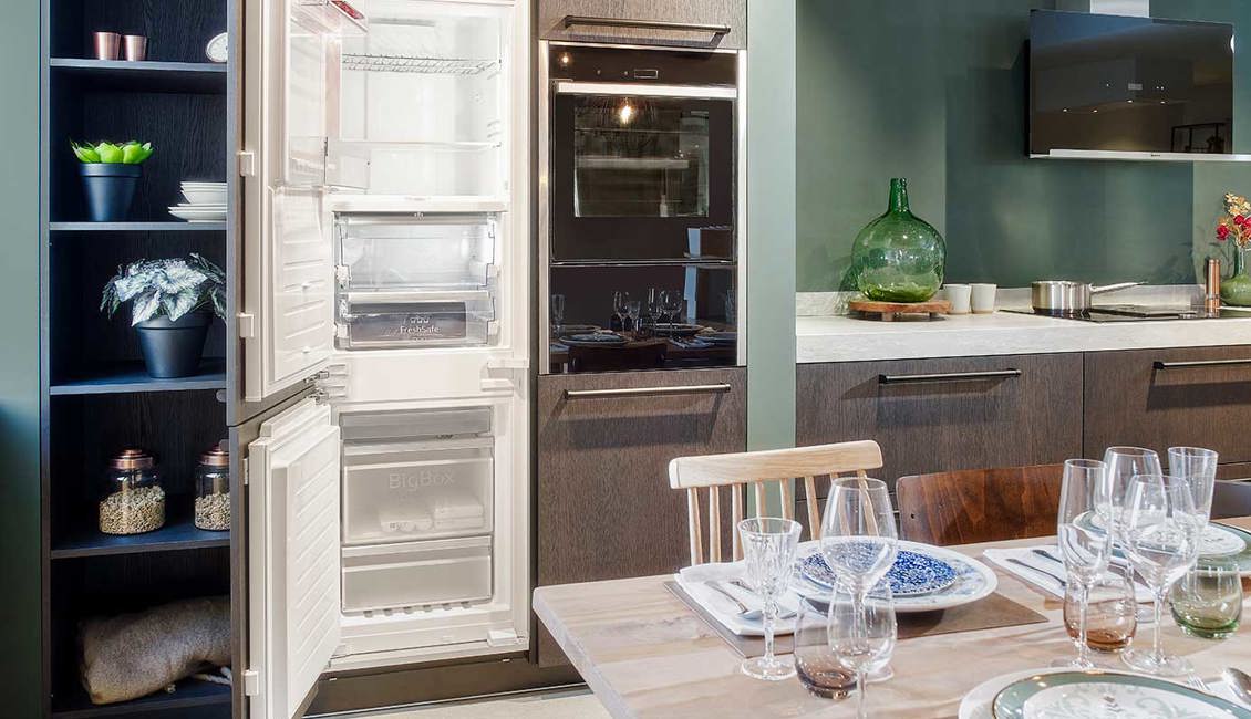 Groene keuken met eiland, koelkast en vriezer