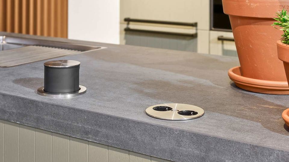 Groene keuken met eiland, stopcontact in werkblad