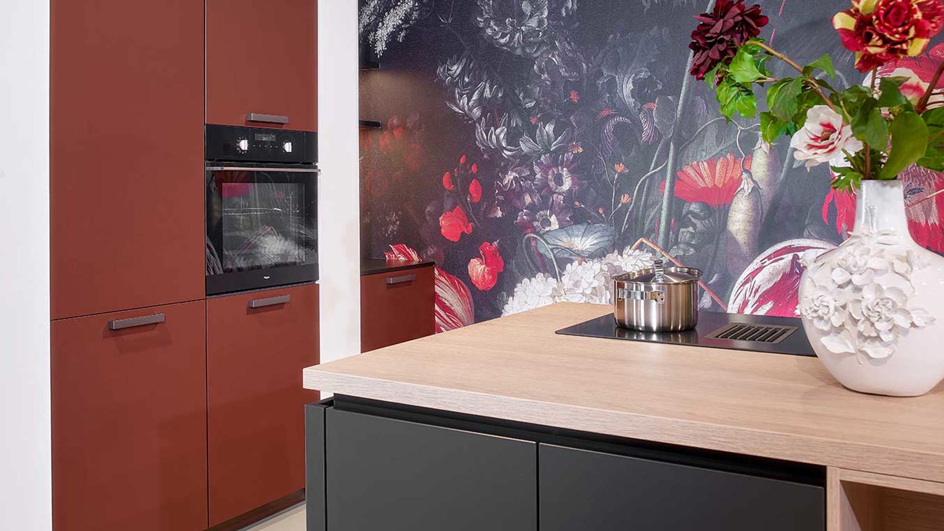 Moderne zwarte keuken met roestrode kastenwand 