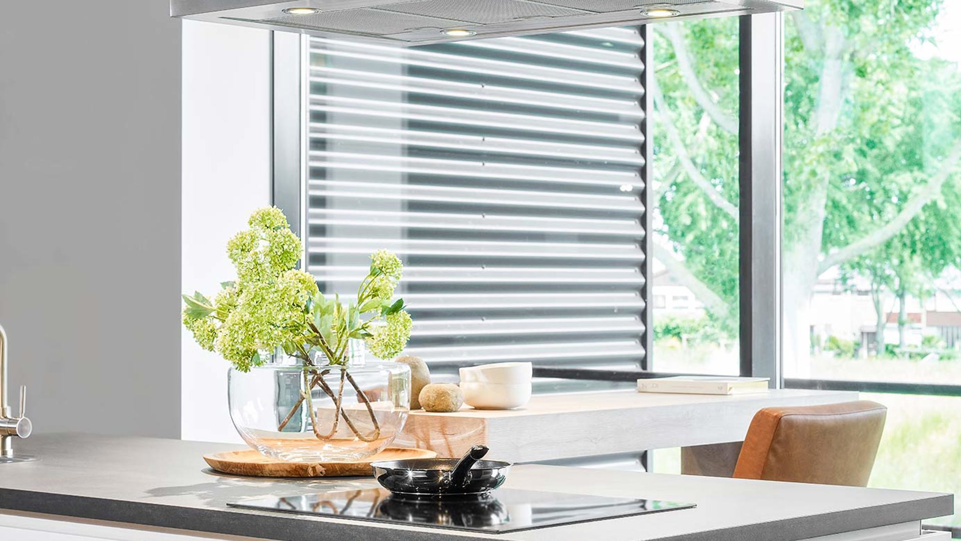 Witte keuken met kastenwand, kookplaat en afzuigkap