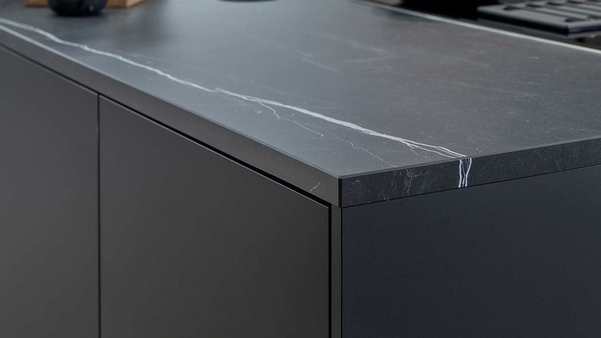 Mat zwarte keuken met marmer aanrechtblad