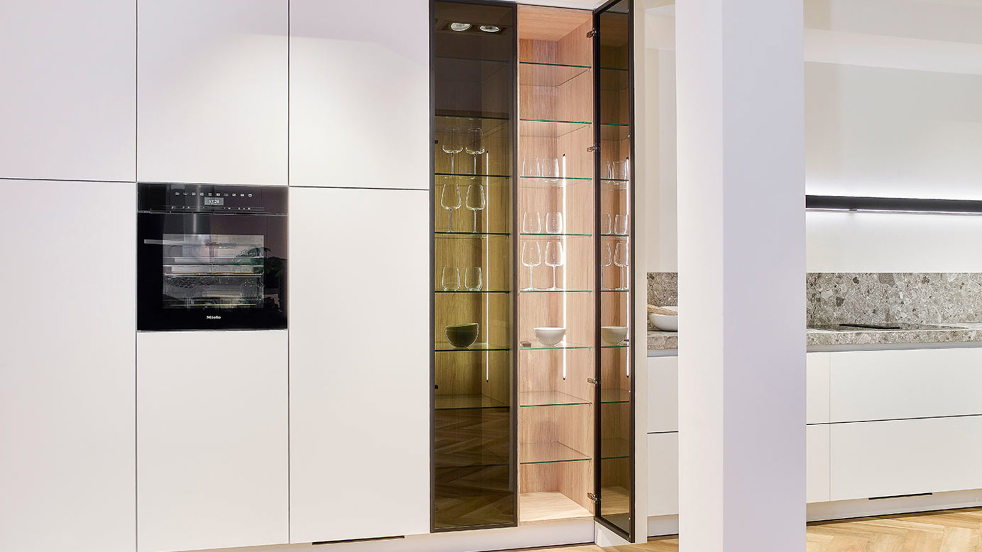 Witte luxe keuken met eiland, hoge kast met glasdeur