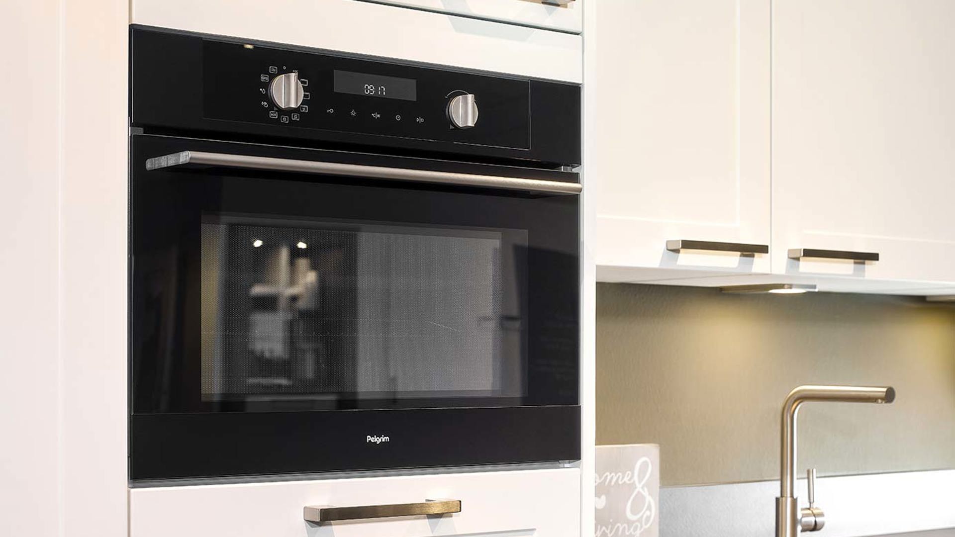 Witte tijdloze hoekkeuken, oven in kastenwand