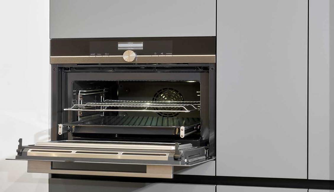 Grijze greeploze keuken met inbouwapparatuur