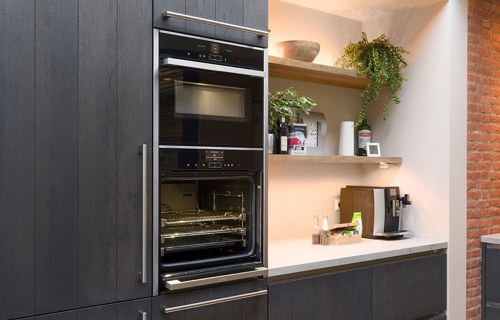 Zwarte keuken houtlook met inbouwapparatuur in Halsteren