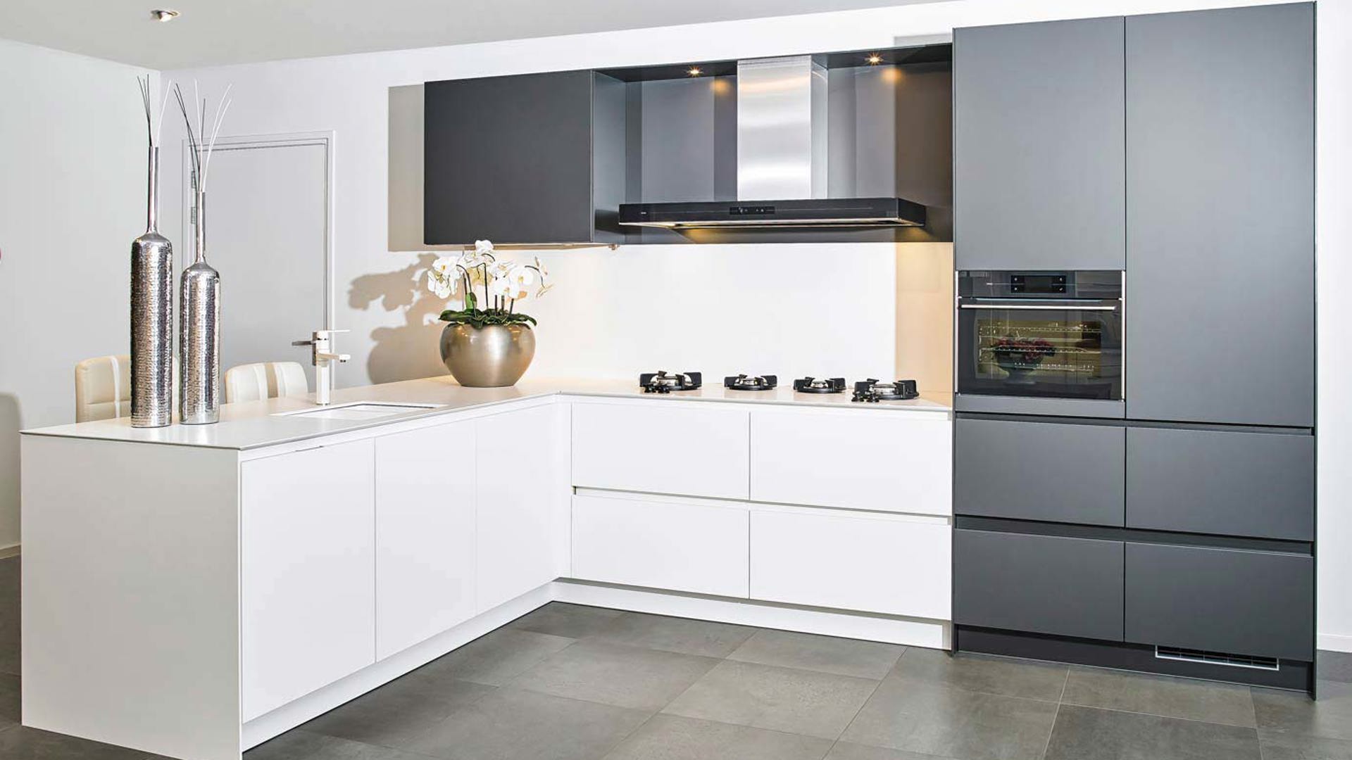 Moderne greeploze keuken in zwart en wit. Met bar en hoogwaardig apparatuur van ATAG, Novy en PITT Cooking.