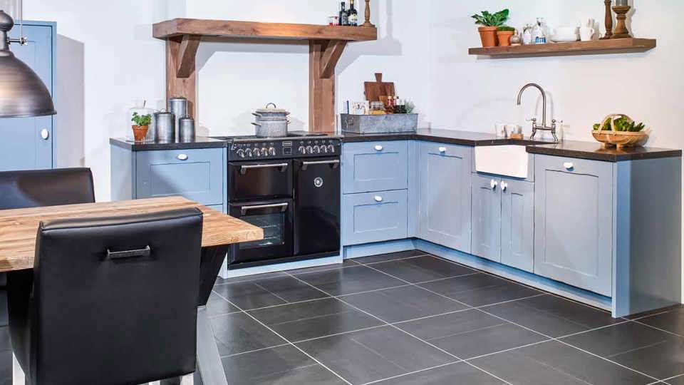 Blauwe houten hoekkeuken in landelijke stijl, met fornuis