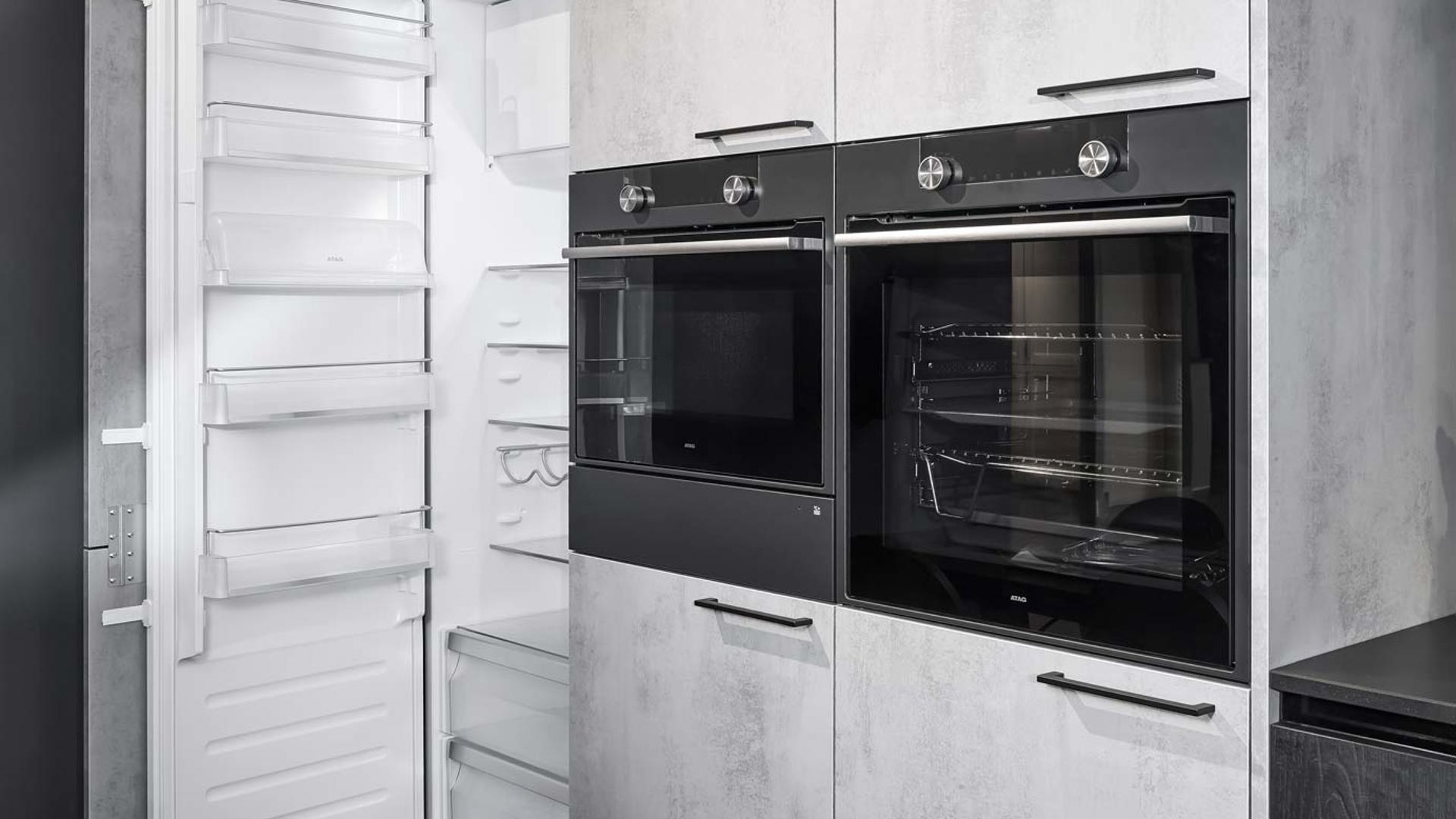 De kasten met betonlook zorgen voor een industrieelindustrieel effect bij de zwarte keuken