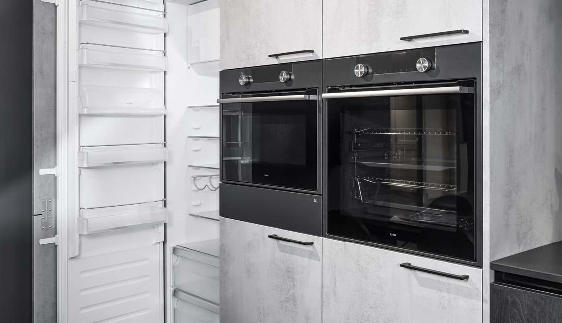 De kasten met betonlook zorgen voor een industrieelindustrieel effect bij de zwarte keuken