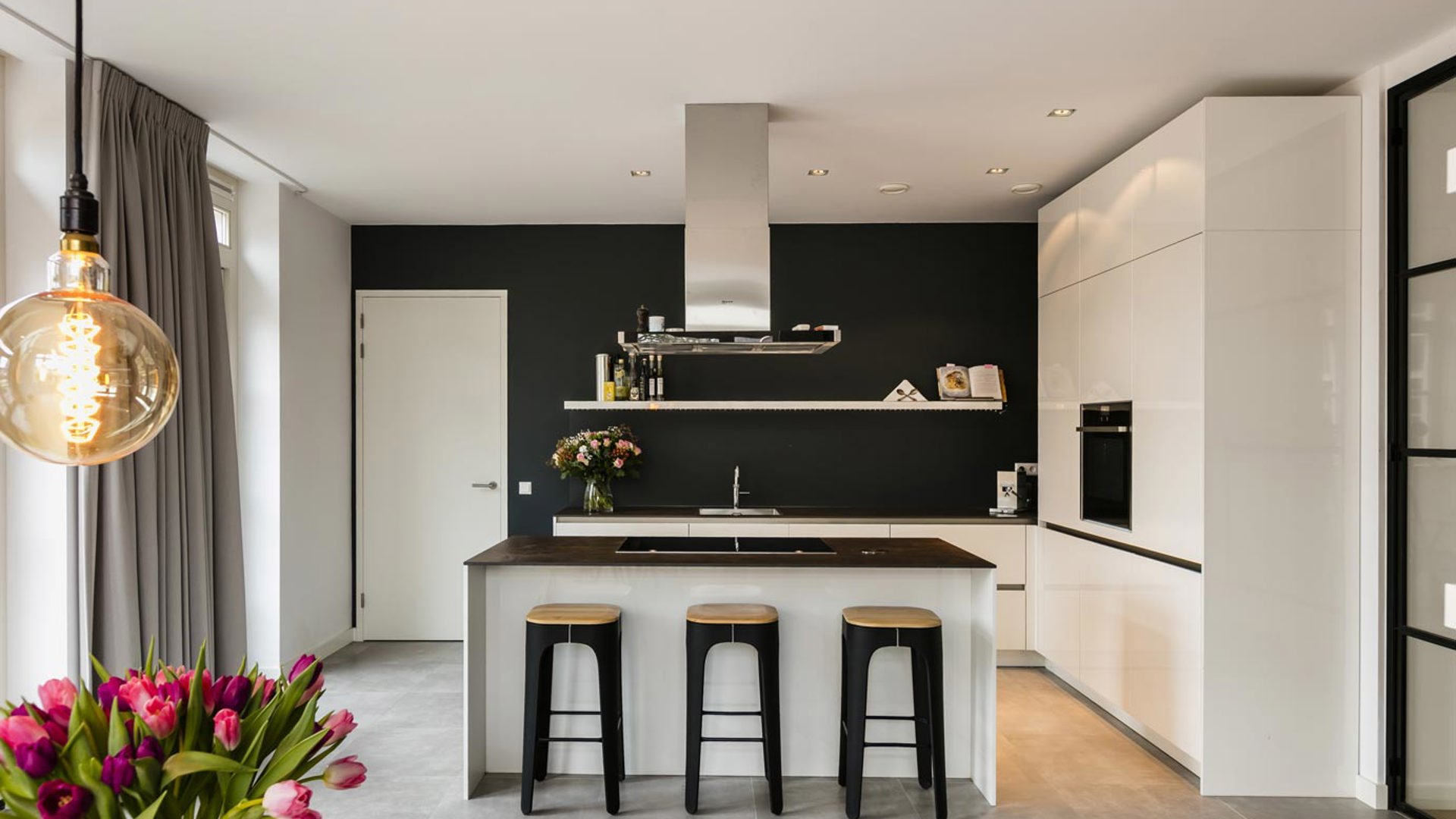Keuken met kookeiland, kastenwand en bar. Geplaatst in Bloemendaal.