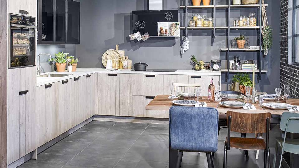 Industriële hoekkeuken met ijzeren wandrekken en houten fronten