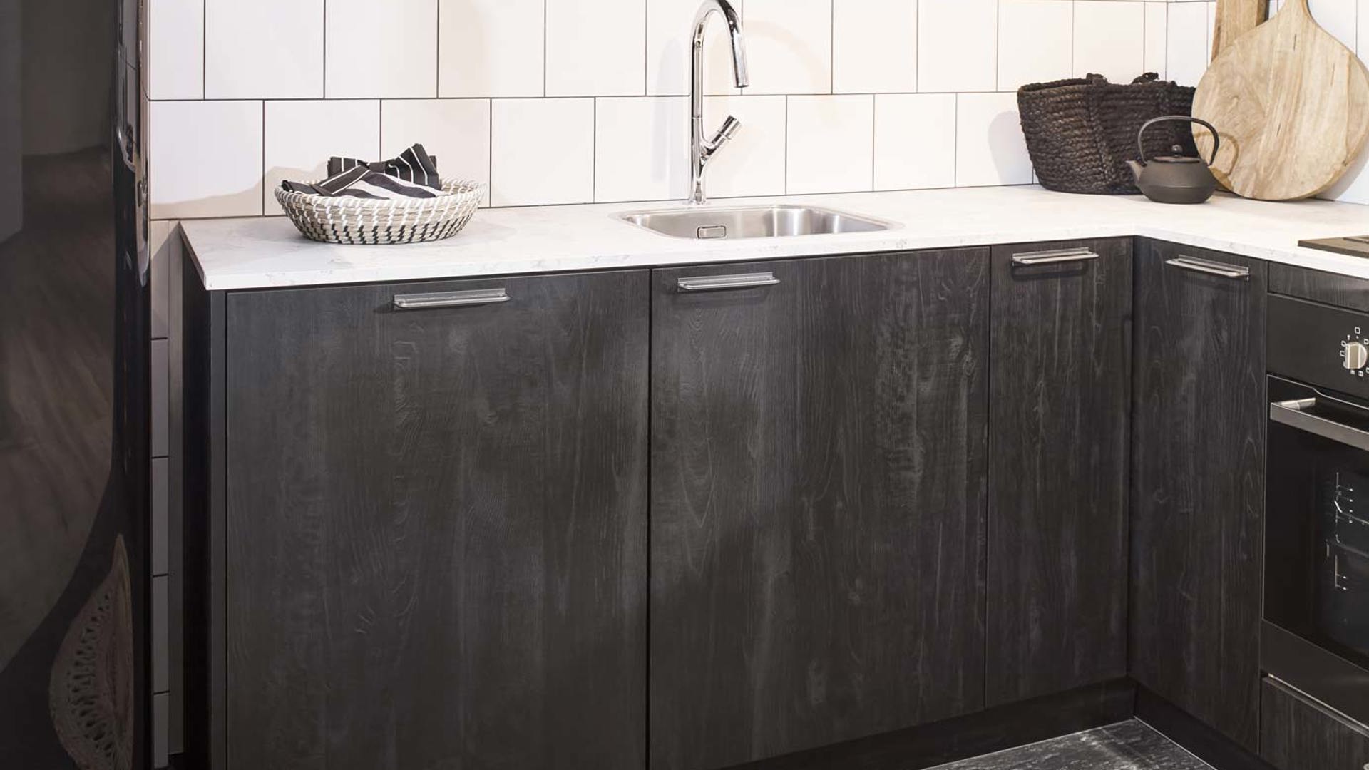 De zwarte fronten in deze Scandinavische keuken hebben een houtlook
