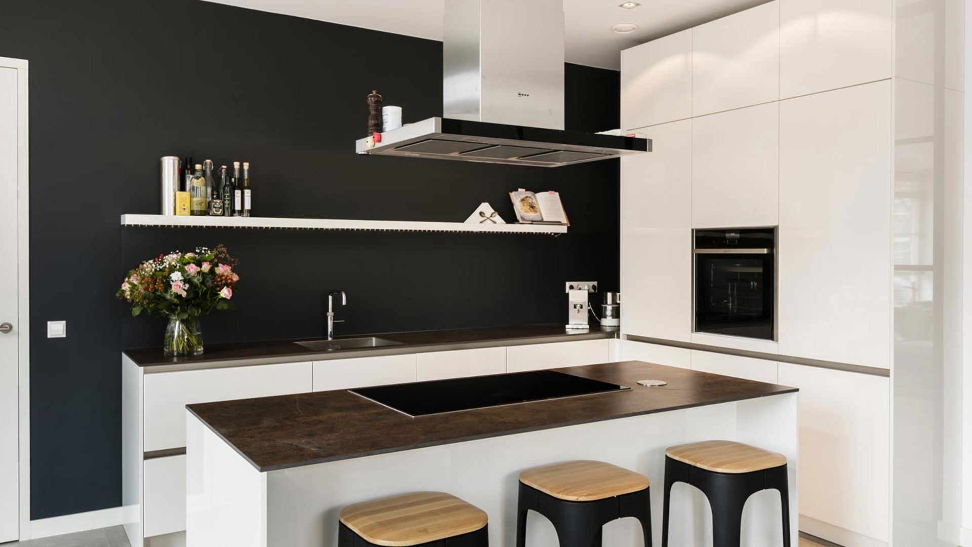 Witte moderne keuken met kookeiland en antraciet achterwand