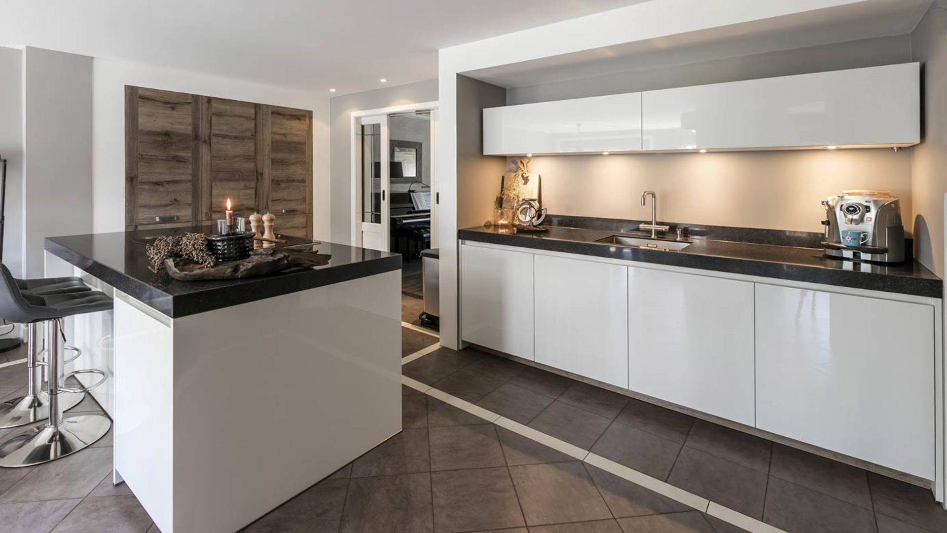 Witte keuken met eiland en houten kastenwand