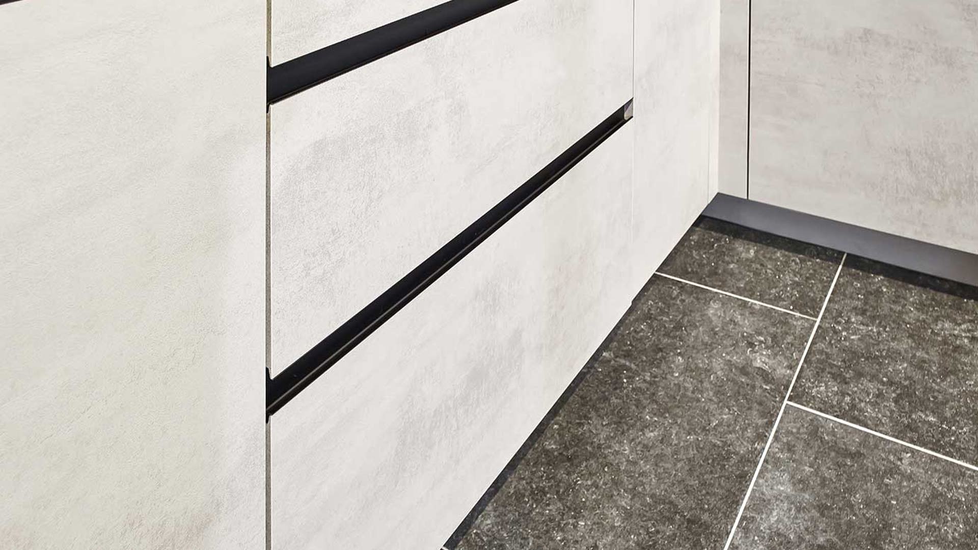 De fronten van de goedkope keuken zijn greeploos en in de kleur betongrijs