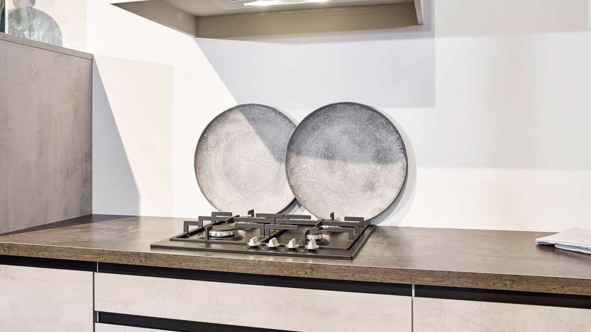 De fronten zijn greeploos en het aanrechtblad is van kunststof in deze moderne keuken