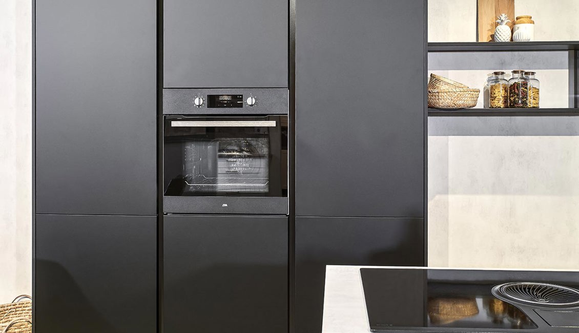 De zwarte kastenwand zorgt voor extra opbergruimte in deze keuken met eiland