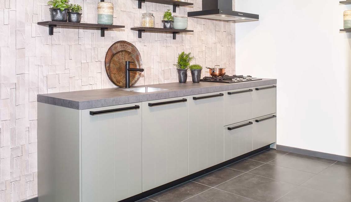 De kleur van deze parallelle keuken is groen, met betonlook kunststof aanrechtblad