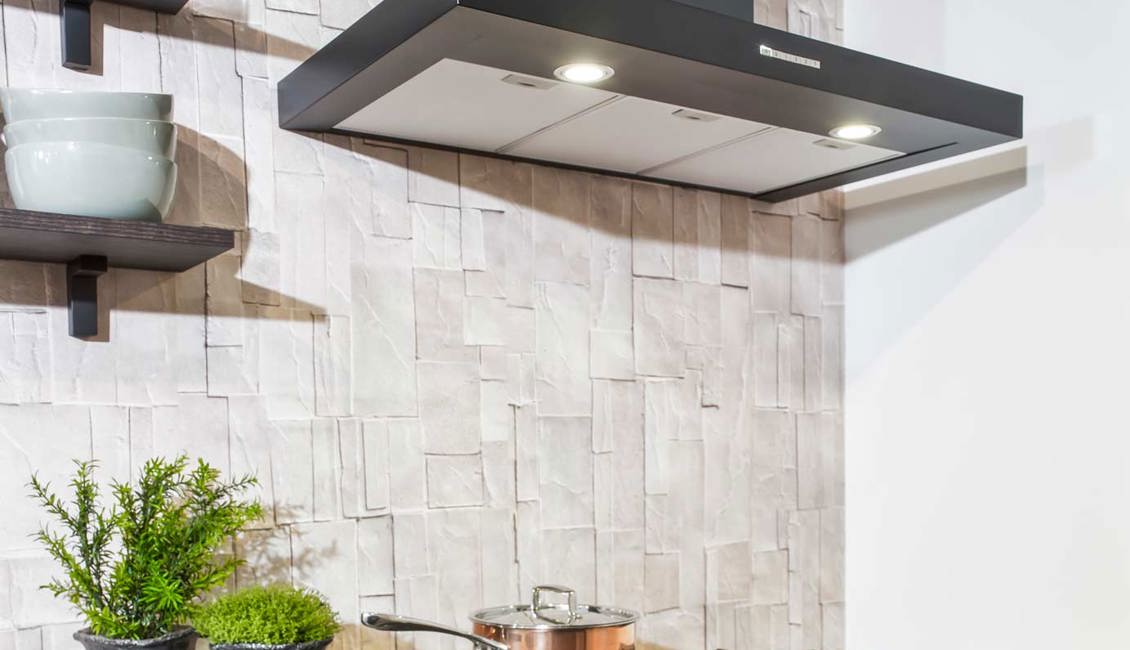 Parallelle keuken met zwarte apparatuur, wat goed past bij het steenbehang