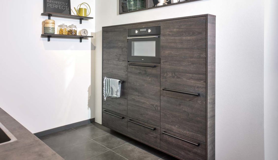 De kastenwand van deze parallelle keuken is ingebouwd, wat een zwevend effect geeft