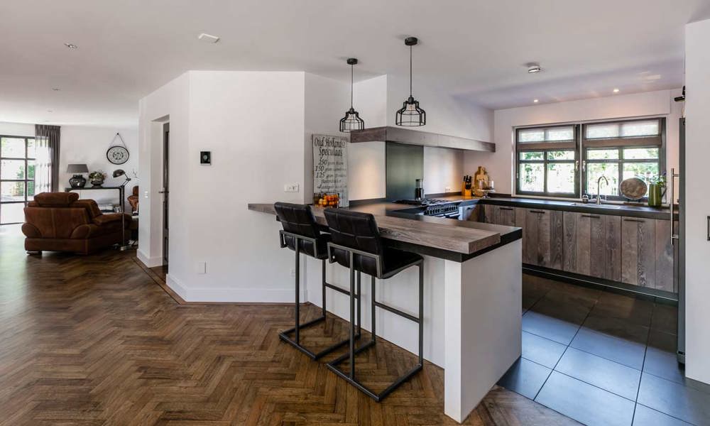 Een houten keuken Gelderland in U-vorm, voorzien van luxe apparatuur
