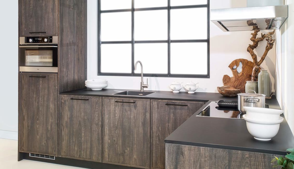 Het aanrechtblad in deze houtlook keuken is donker uitgevoerd